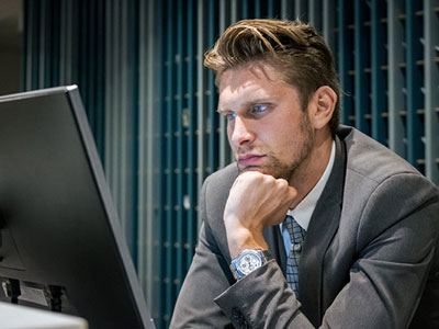 attorney looking at computer screen considering post settlement funding for his practice