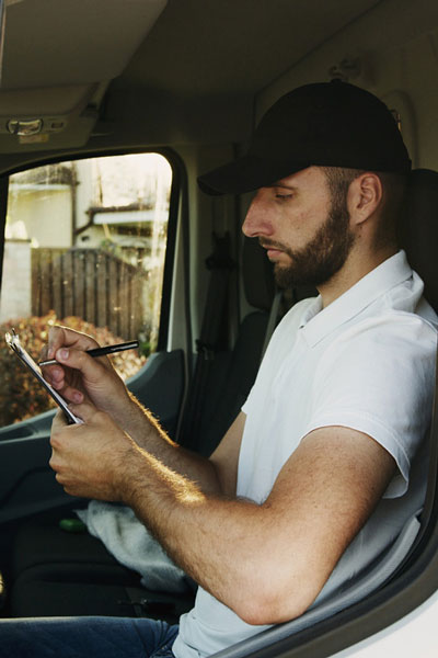 trucker filling out a bill of lading in the cab of his truck