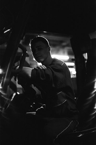 young truck driver in the cab of his truck smiling with the door open