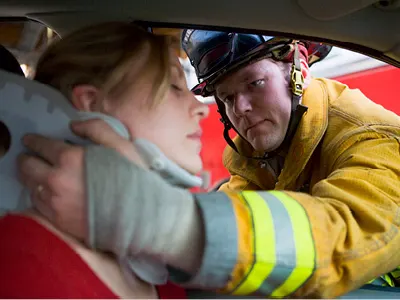 fireman helping woman in car accident with semi truck