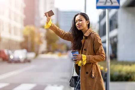 woman waves for her uber driver