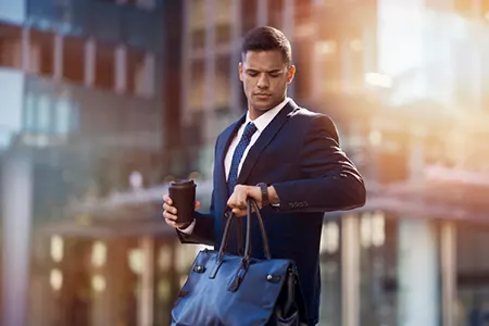 young lawyer checking his watch on the way to work timing delays